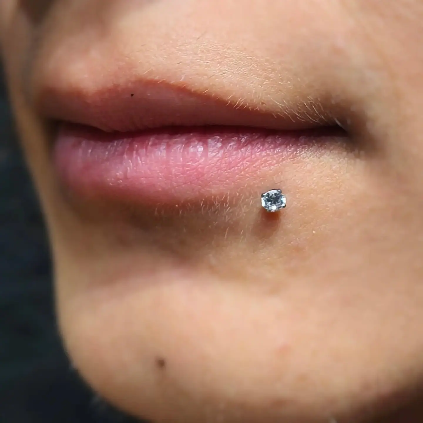 Piercing labret no lábio com joia de titânio